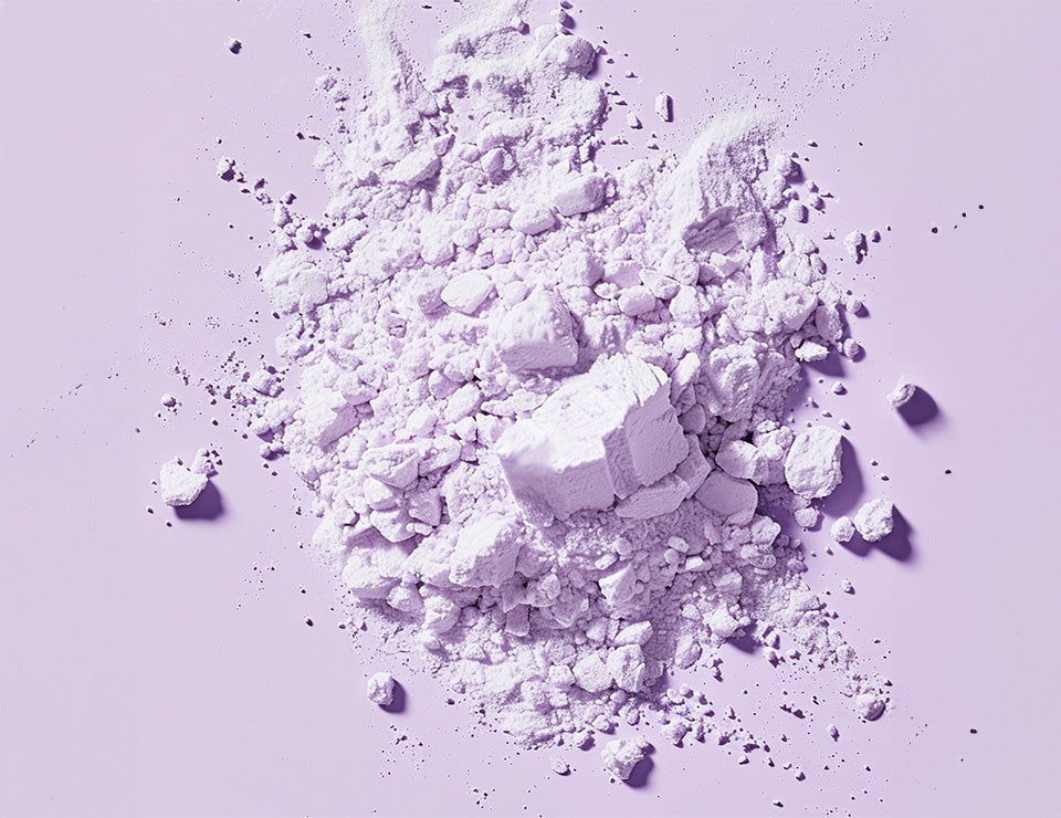 Es ist ein lila Pulver zu sehen, das die Darstellung von dem Wirkstoff Allantoin verdeutlicht.