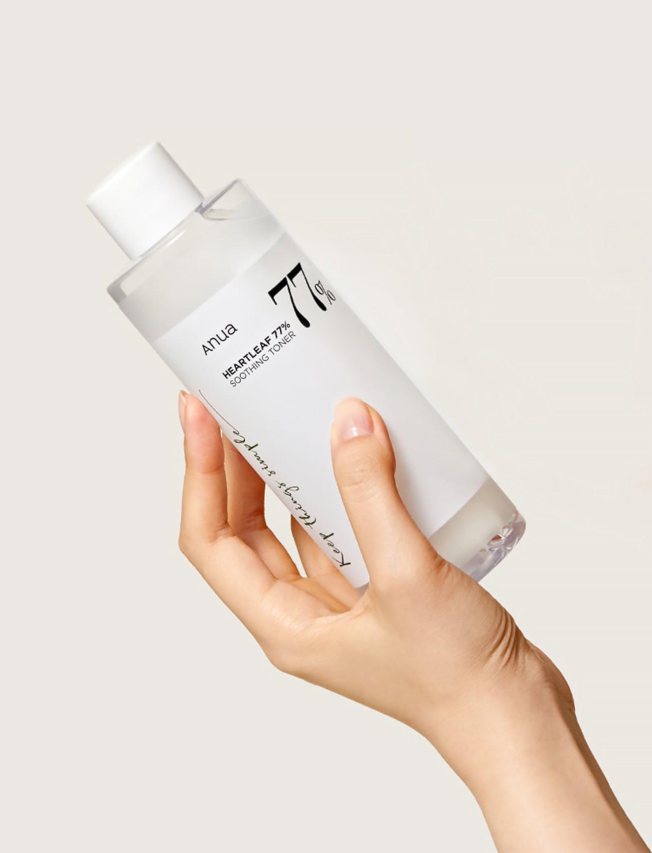 Eine Person hält den Heartleaf 77% Soothing Toner in der Hand hoch.