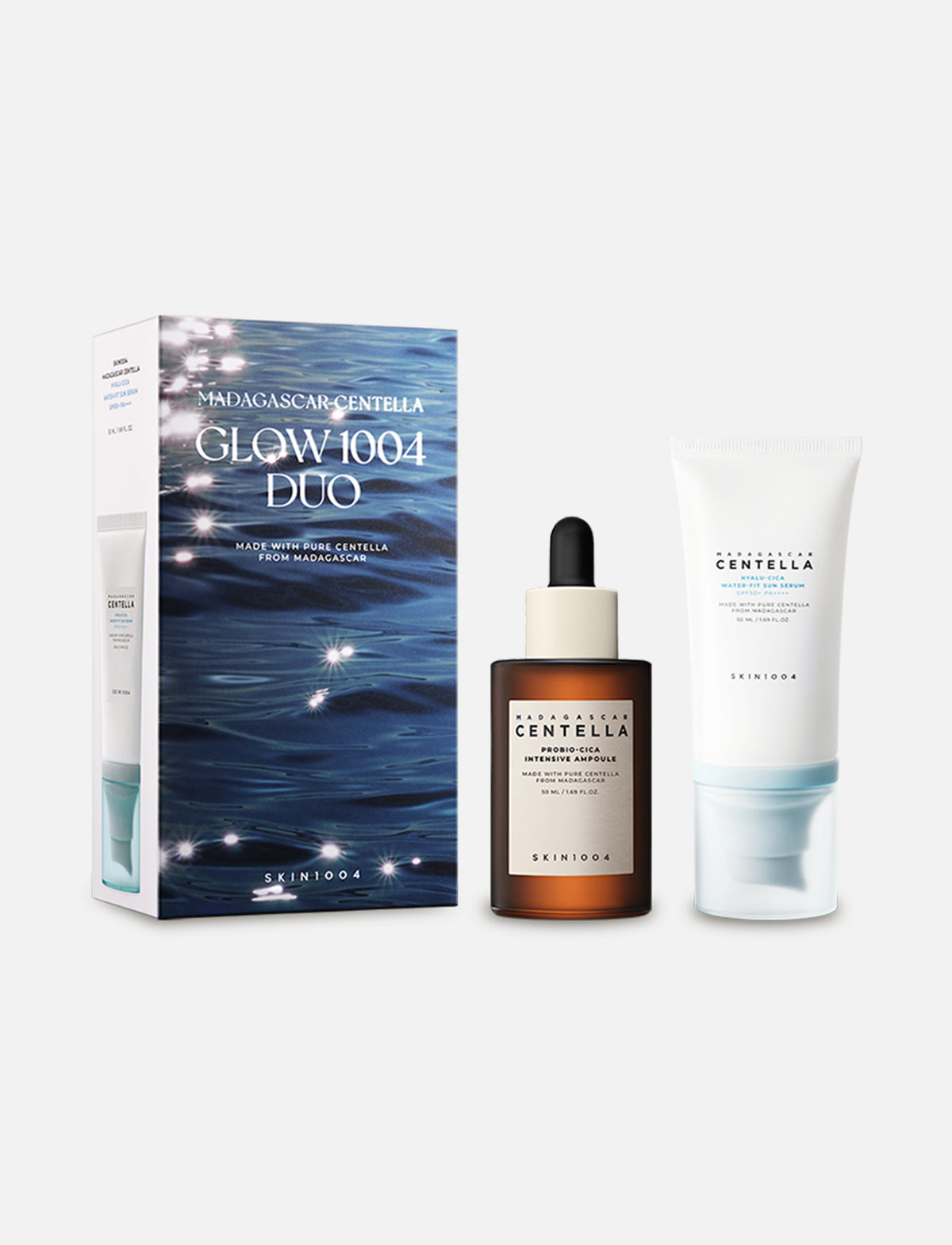 SKIN1004 Madagascar Centella Glow 1004 Duo Set mit Produktverpackung, Probio-Cica Intensive Ampoule (50 ml) in braunem Glasflakon mit Pipette und Hyalu-Cica Water-Fit Sun Serum (50 ml) in weißer Tube mit blauem Detail, vor hellem Hintergrund.